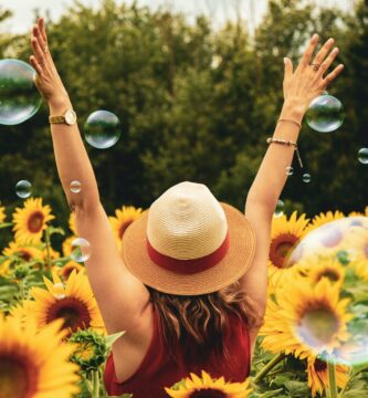 woman surrounded by sunflowers