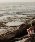 photo of woman sitting on rock