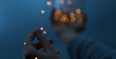 woman holding a yellow string light