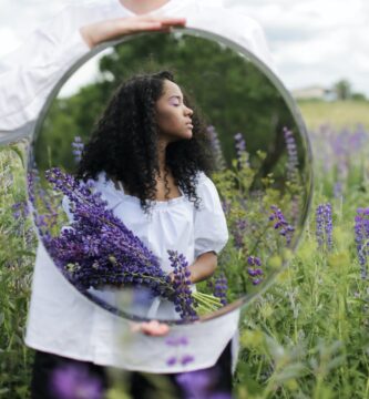 woman in white shirt holding purple flowers
