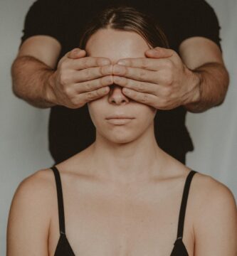 crop man covering eyes of anonymous woman