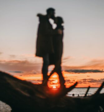 faceless couple on coast of sea