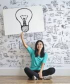 woman draw a light bulb in white board