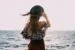 stylish woman enjoying windy day on coast